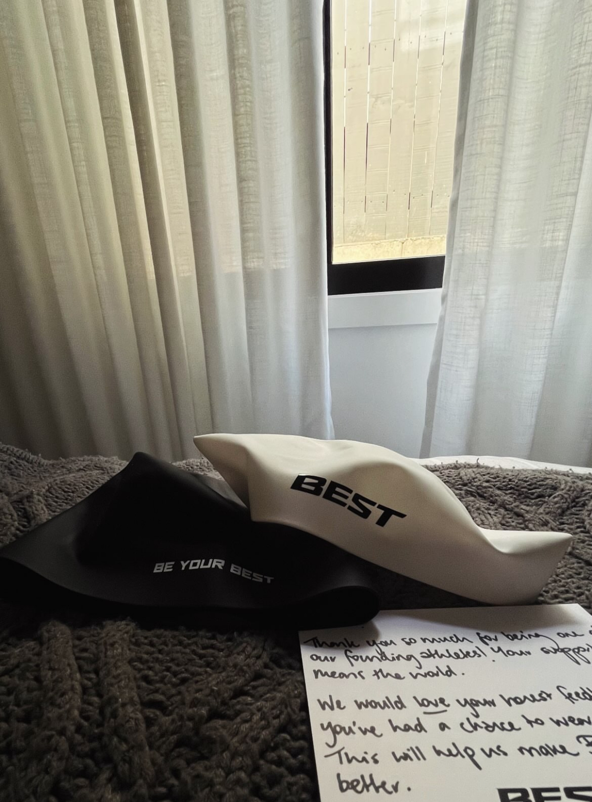 Black and white BEST caps beside a handwritten thank-you note